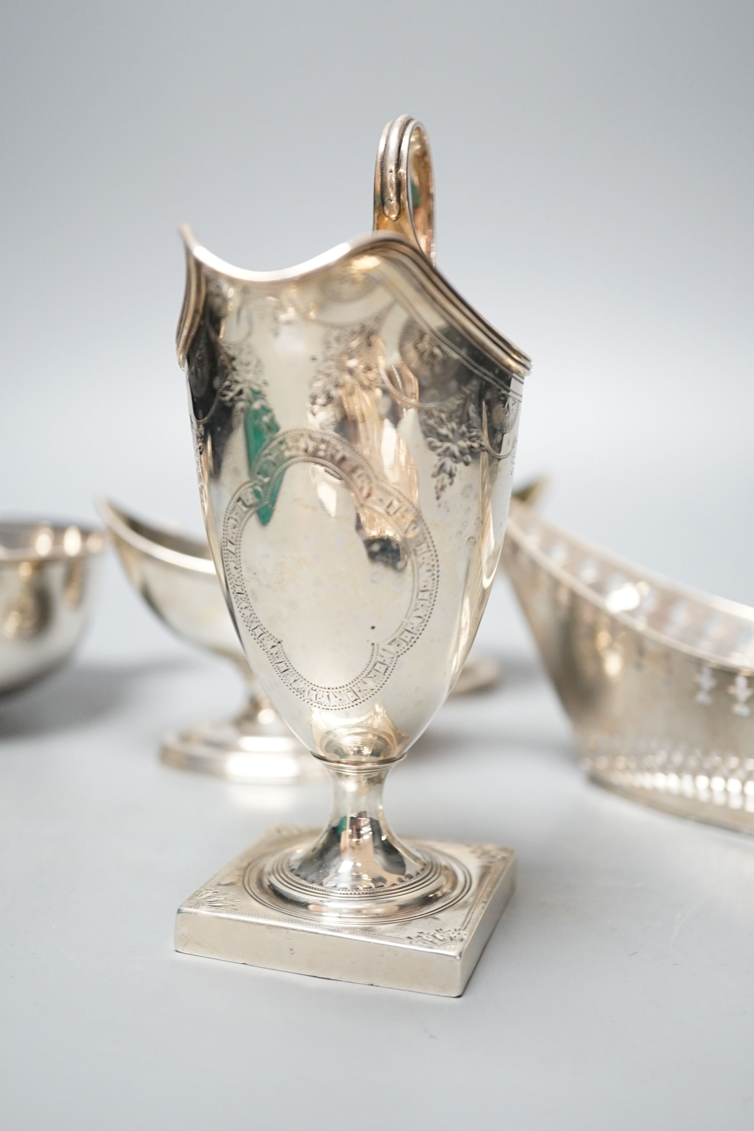 A mixed collection of silver to include a Scottish quaich, a pair of George III boat shaped salts, a George III silver helmet shaped cream jug and a pierced boat-shaped bowl, 17oz.